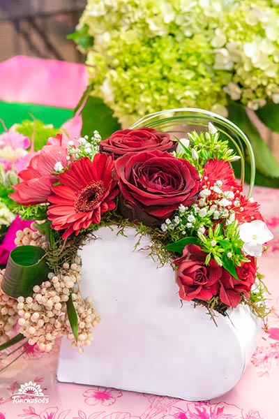 Compo de roses et fleurs rouges et blanches dans un pot de bois blanc en forme de coeur